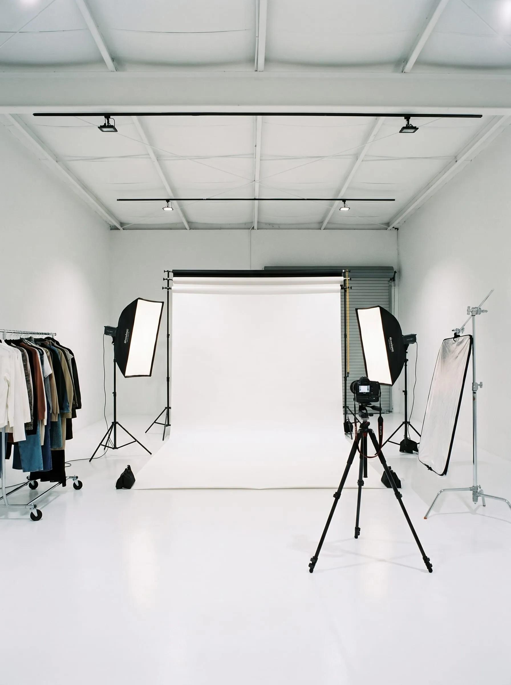 A photography studio setup with backdrop and lighting in the space