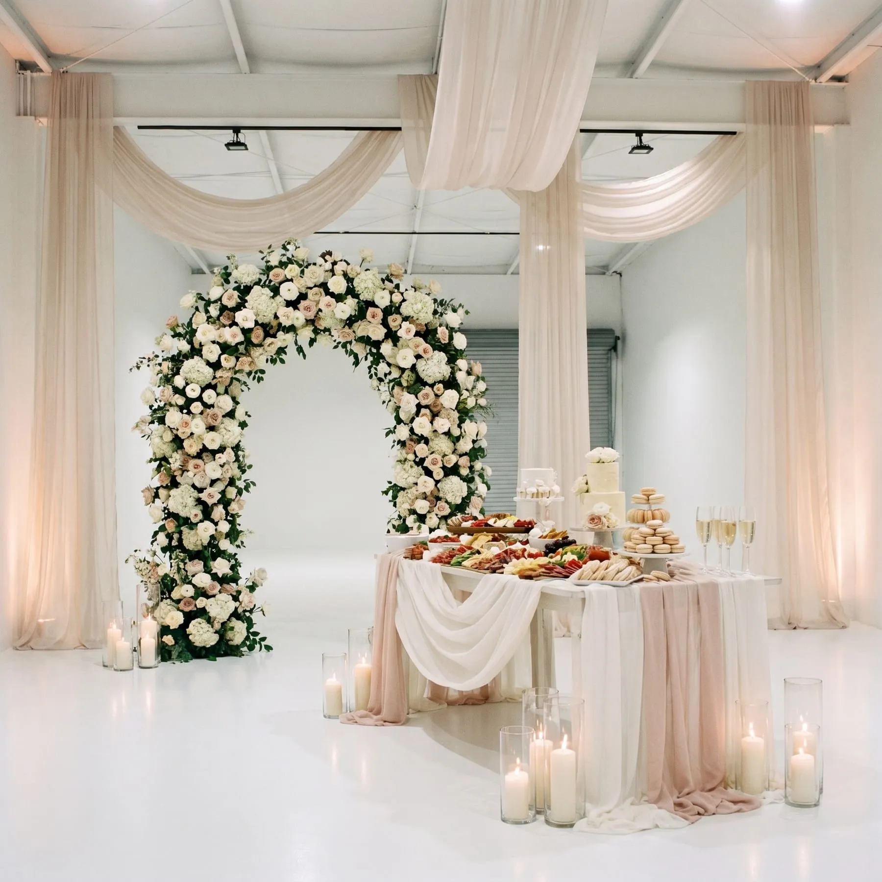 The studio styled for a bridal shower with a floral arch and dessert table