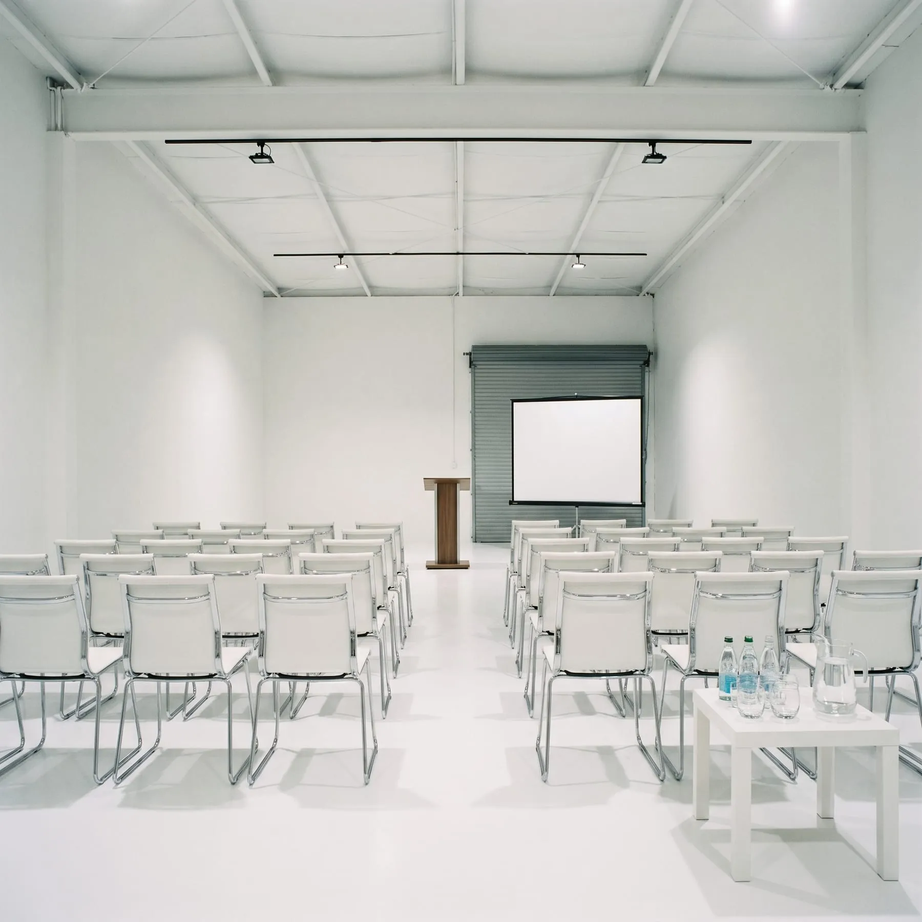 Rows of chairs facing a screen and lectern set up for a seminar